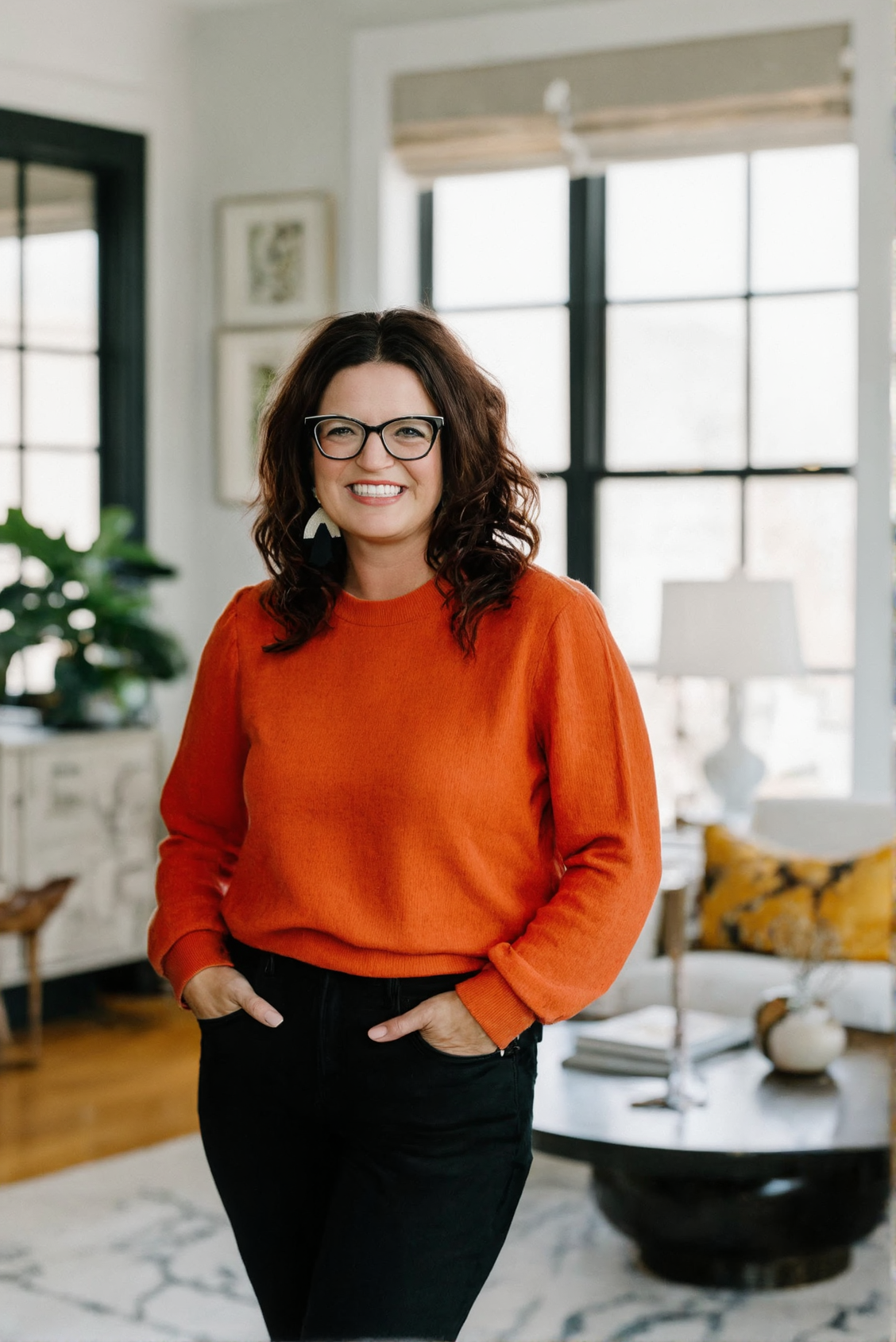 Sarah Lavin, standing in a styled living room