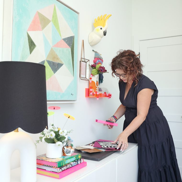 Sarah styling a white credenza beneath a geometric painting and a ceramic cockatoo