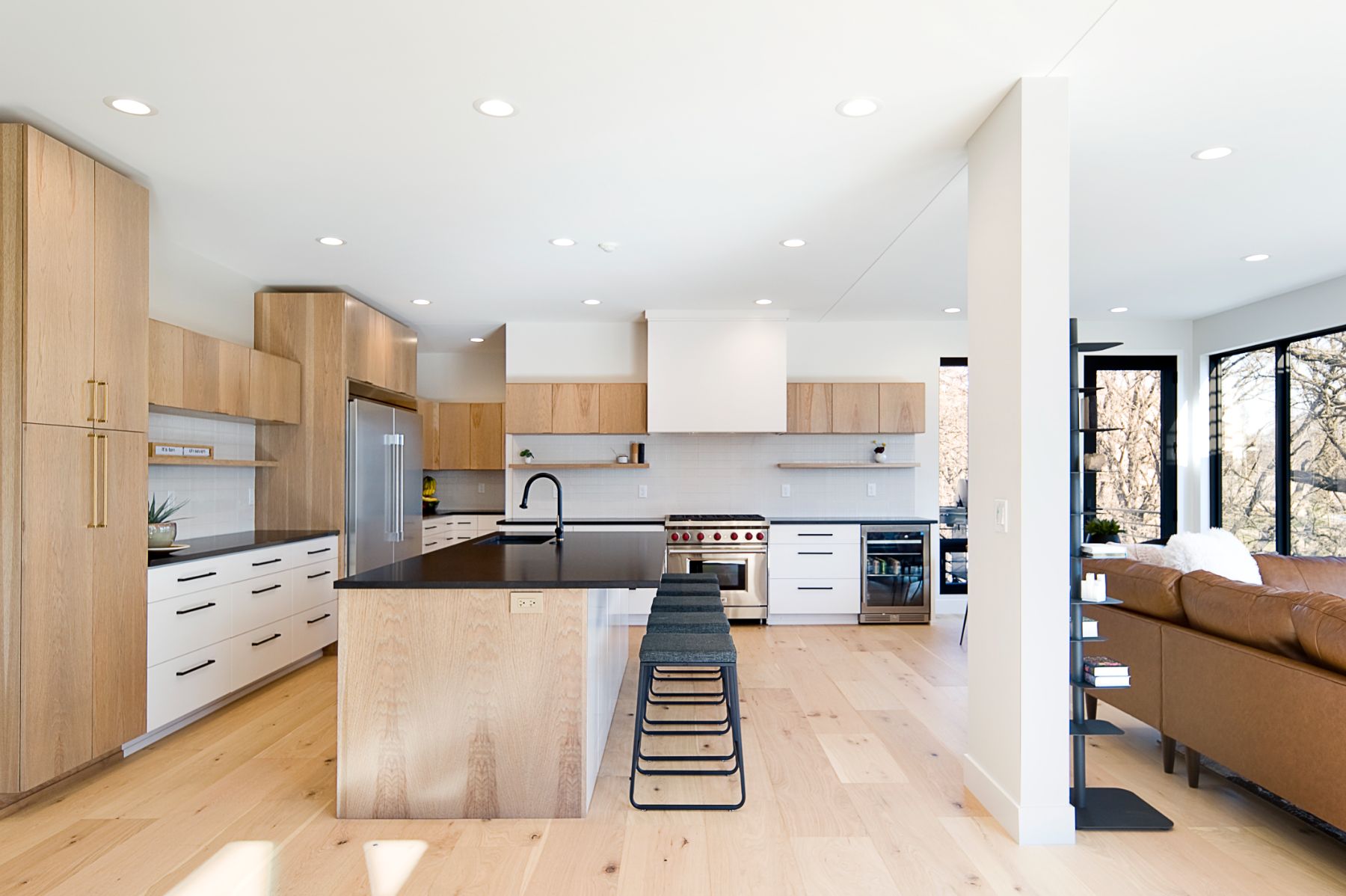 White oak kitchen with a black island and white oak floors