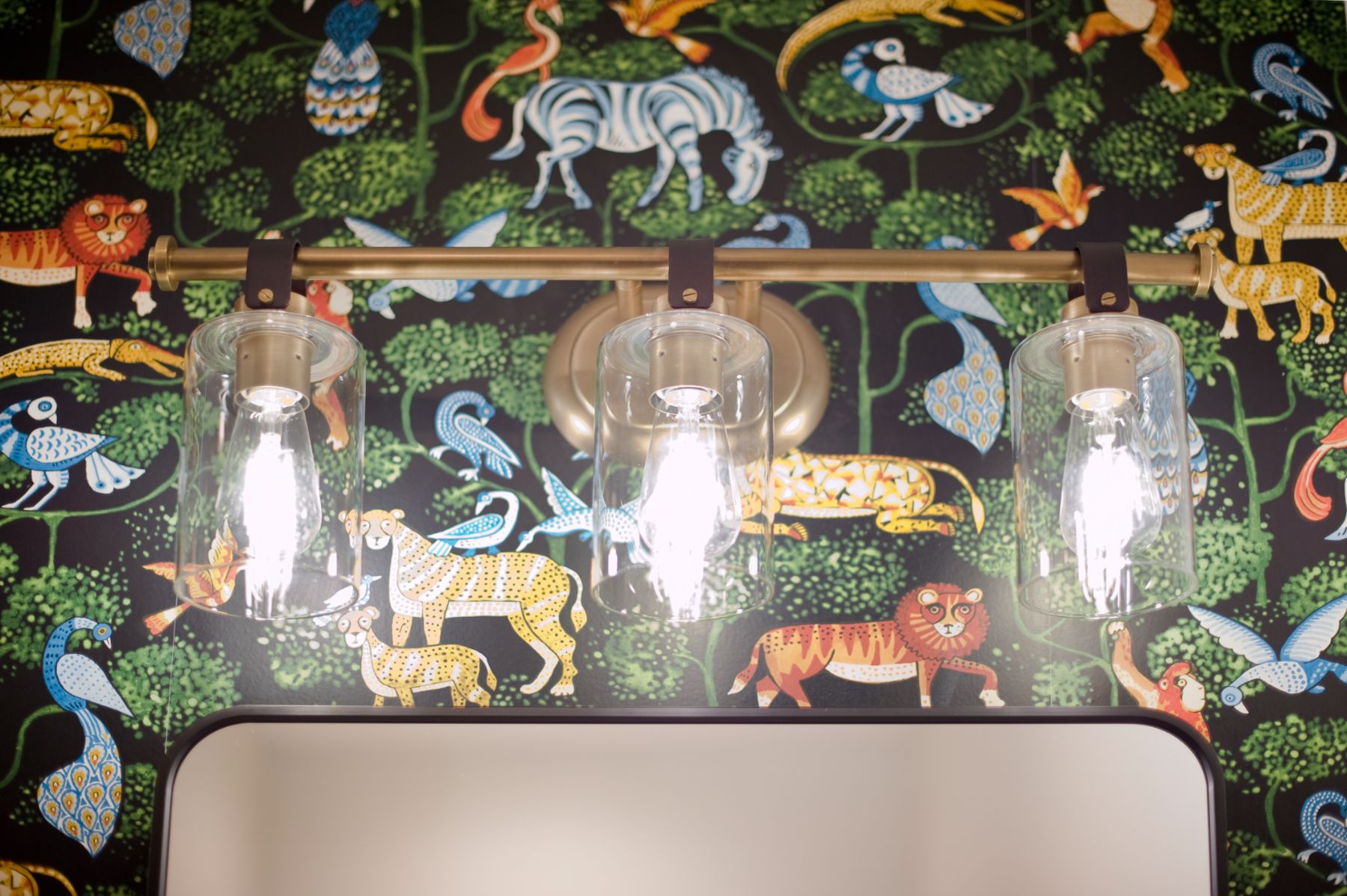 Safari wallpaper detail behind three glass pendant lights