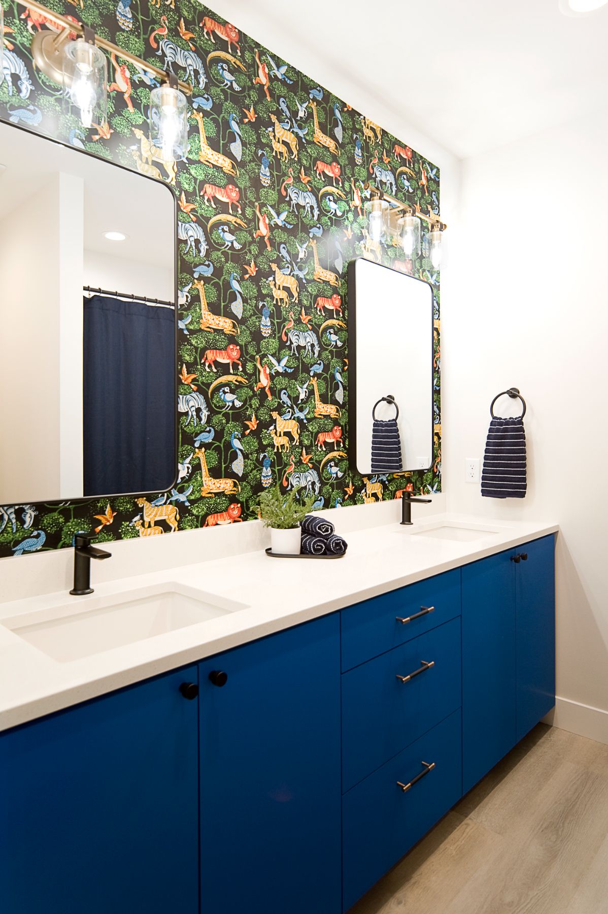 Powder bath with safari wallpaper and a navy vanity