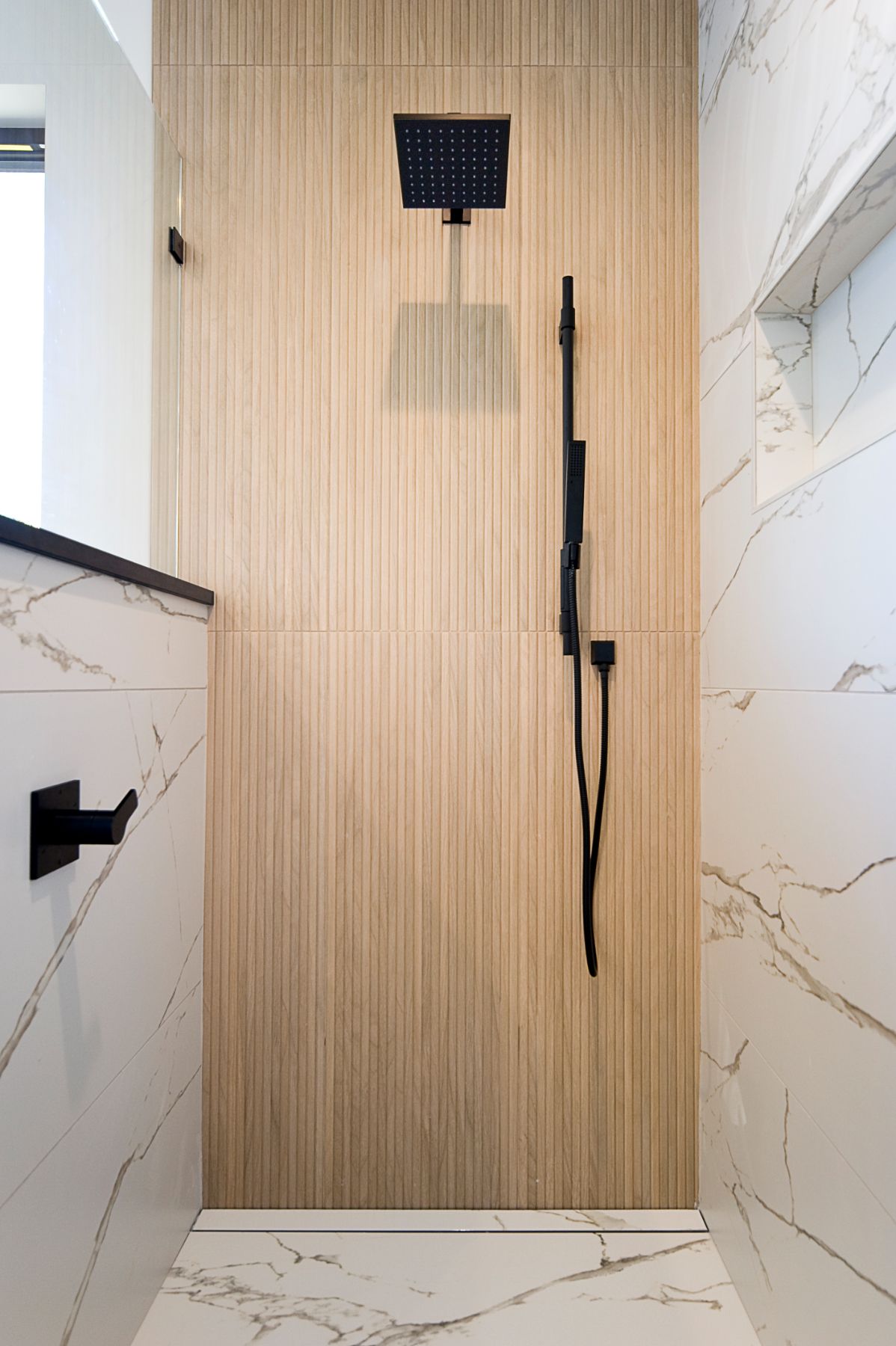 Marble shower with a white oak slat accent wall