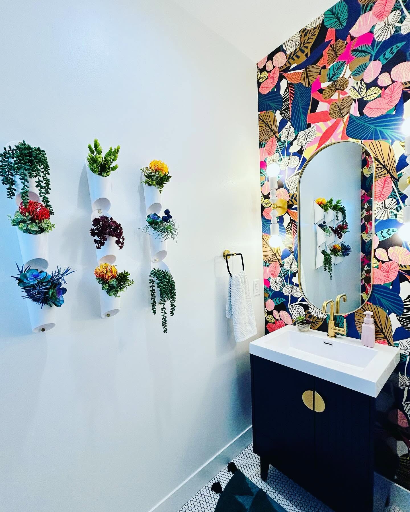 Botanical wallpaper powder bath with a navy vanity